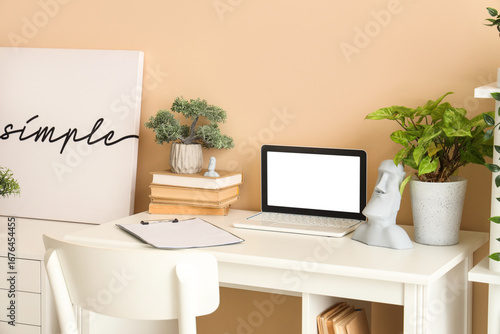 Blank laptop with books and...