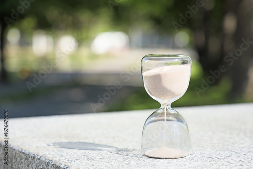 Hourglass on concrete in pa...