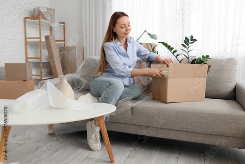 Young woman packing box in ...