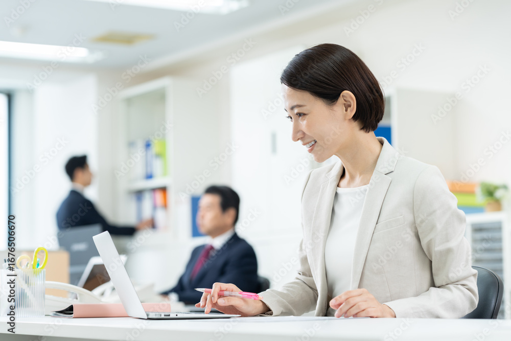 Fototapeta premium オフィスで働くミドルのビジネスウーマン