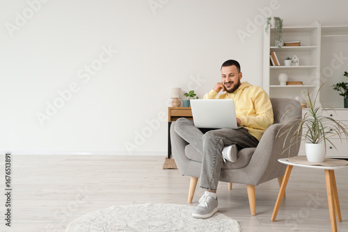 Handsome man using laptop i...