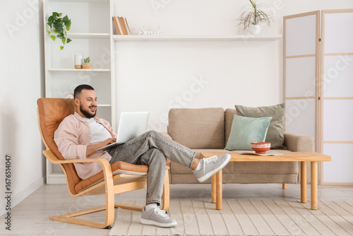 Handsome man using laptop i...