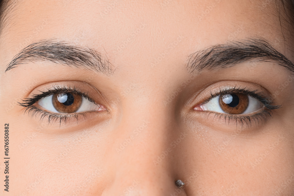 Naklejka premium Young woman with brown eyes, closeup