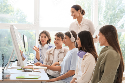 Fotografi Female teacher conducting lesson to students at school computer lab