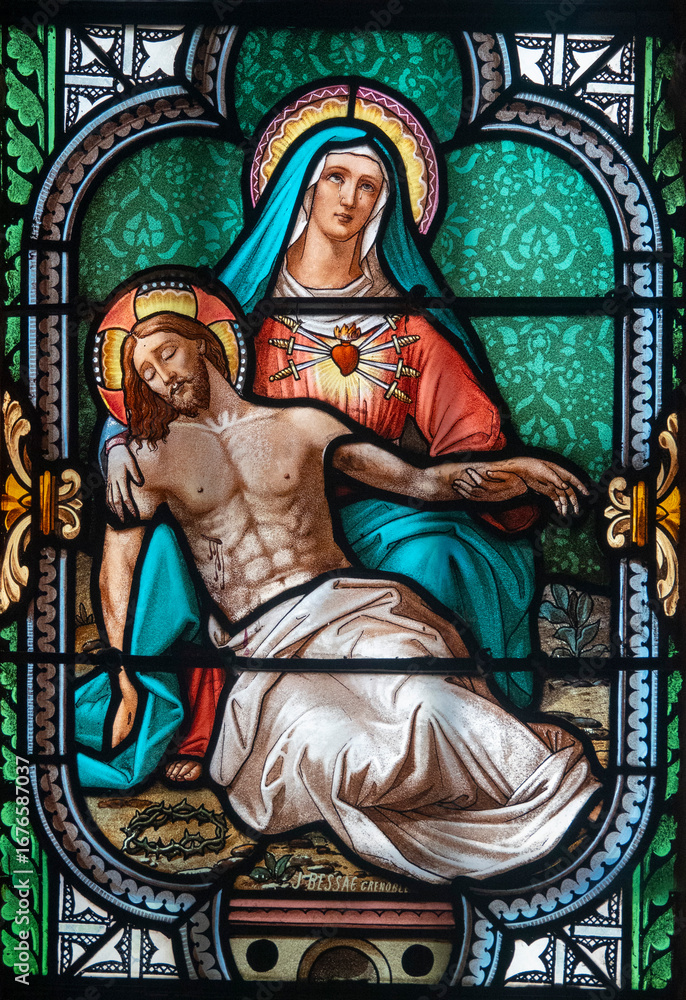 Fototapeta premium Stained glass (19th century) of Pieta (Madonna of Seven Sorrows). Blessed Virgin Mary holding Jesus Christ body after his Deposition from the Cross.