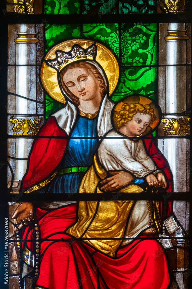 Fototapeta premium Stained glass (19th century) of Blessed Virgin Mary holding baby Jesus Christ in her arms.
