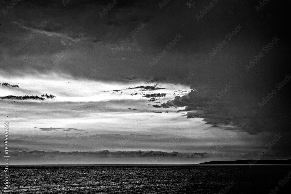 Obraz premium Sunset on the sea shore with dramatic sky