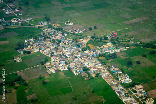 Aerial View of a Rural Indian Village Surrounded by Lush Green Paddy Fields