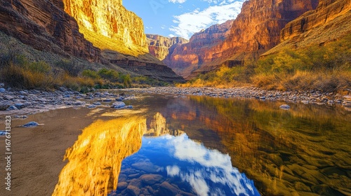 A stunning view of towering canyon walls reflected in a tranquil river, showcasing vibrant colors and dramatic geological formations.
