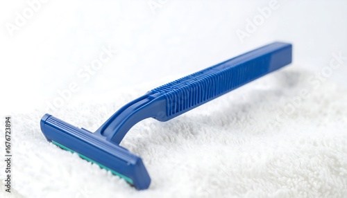Blue disposable razor on white towel