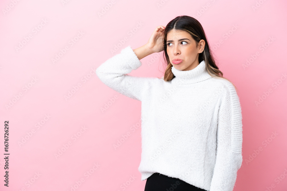 Fototapeta premium Young Italian woman isolated on pink background having doubts while scratching head