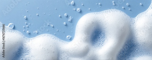 Close-up of light-blue surface covered with white sudsy foam and small bubbles