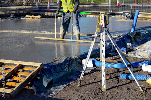 Vászonkép Workers are smoothing out a newly poured layer of concrete