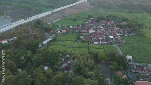Aerial View of a Serene Rural Village Surrounded by Lush Green Fields and Infrastructure