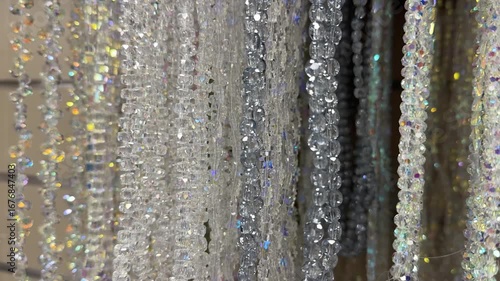 Strands of sparkling crystal beads with iridescent reflections hanging in a display