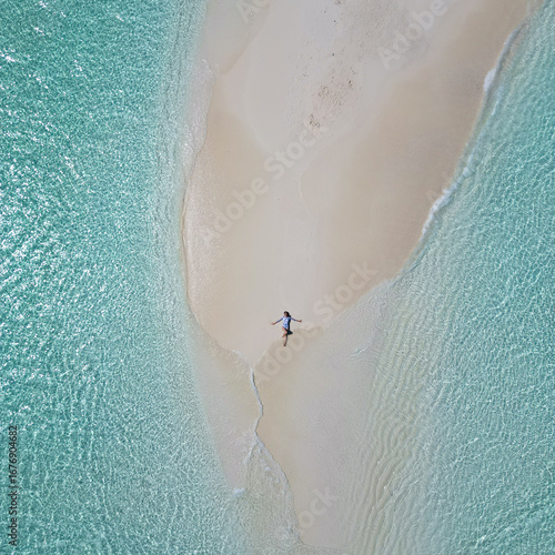 Woman enjoys the crystal-clear water of Maldives by laying on the sandbank in the middle of nowhere 