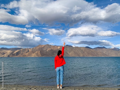 Female traveler enjoys the Pangong lake in Leh Ladakh, Northern India - amazing road trip along the beautiful nature and high mountains 