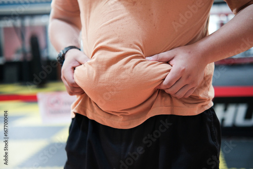 Overweight man holding his belly fat. Weight loss and diet concept.