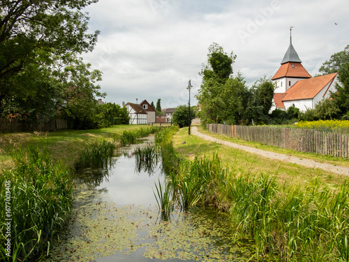 A boulevard along a river in the historial village of Swołowo in Poland. 