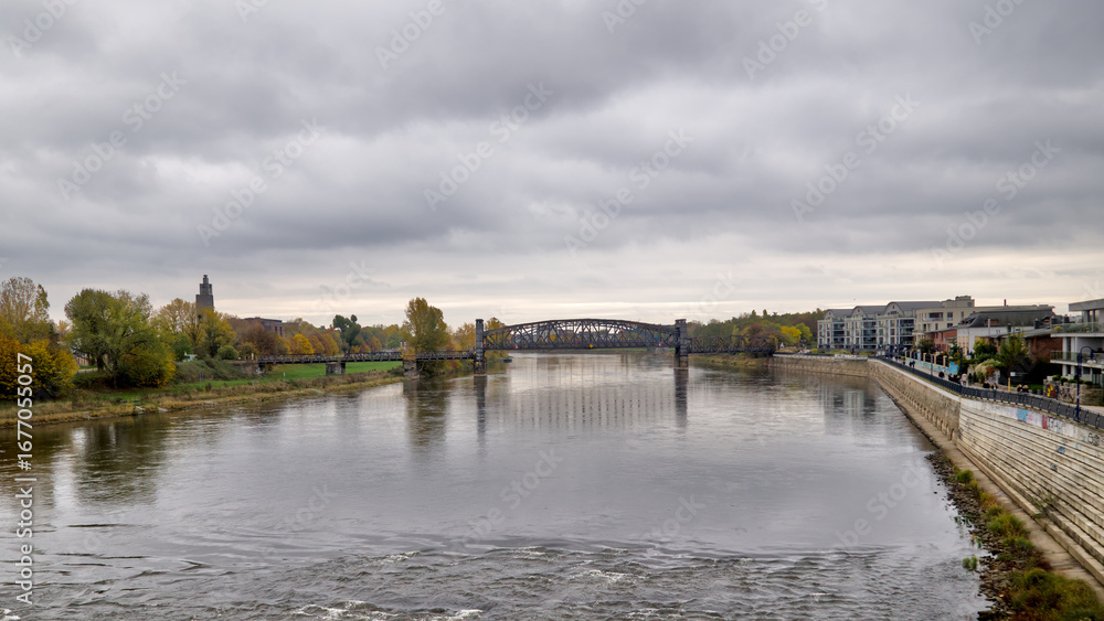 Obraz premium View of the Elbe River from the observation platform near the Domfelsen in Magdeburg under an overcast sky.