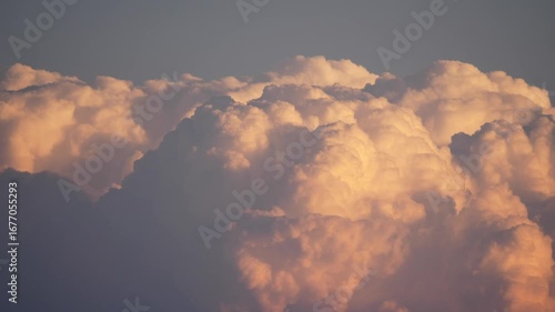 Left to right pan past glowing top of cumulonimbus cloud at sunset in Africa 