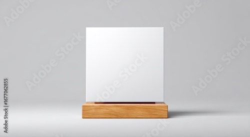 Blank white square sign on a light brown wooden pedestal against a neutral gray background.  A simple, clean presentation