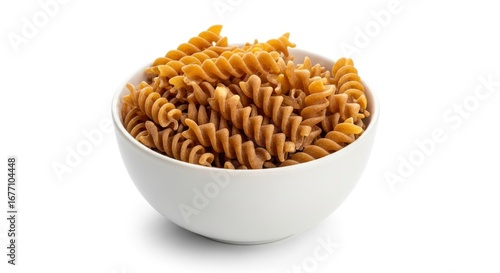 A bowl filled with spiral pasta likely whole wheat against a white backdrop
