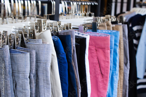Papier peint A row of brightly colored pants hangs on a clothing rack, showing a variety of c