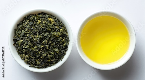 Two white bowls, one filled with loose leaf green tea, the other with brewed green tea