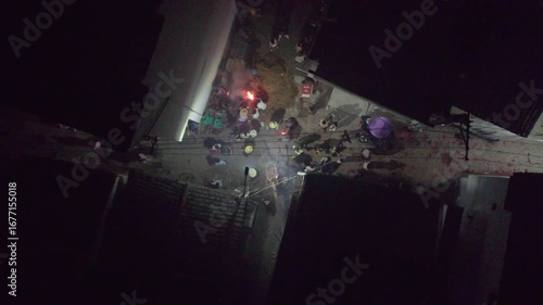 Drone view of crowded people burning incense during New Year celebrations in Wuyuan, Jiangxi, China. Top view of villager prepare grass dragon dance in spring festival at night, 4k real time footage.