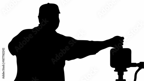 Silhouette of a man wearing a cap operating machinery with his hand extended in a black and white image