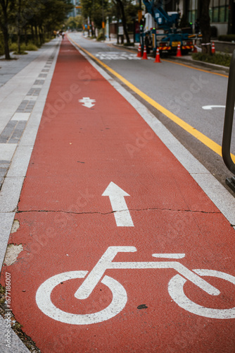 A Red Bicycle Lane with White Arrows and a Bike Symbol