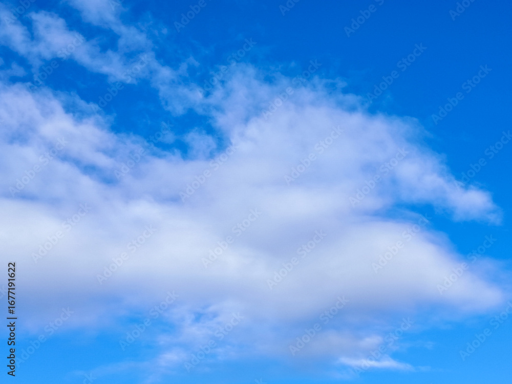 Naklejka premium Fluffy White Clouds in a Bright Blue Sky