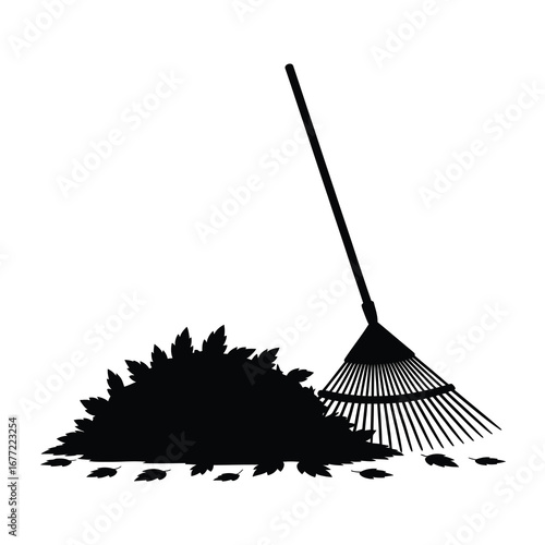 Silhouette of a garden rake and a pile of fallen leaves ready for yard work