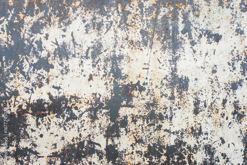 The walls are covered in peeling paint and have a rough texture. The blue color of the walls is faded and has a worn appearance. The walls have numerous cracks and holes.