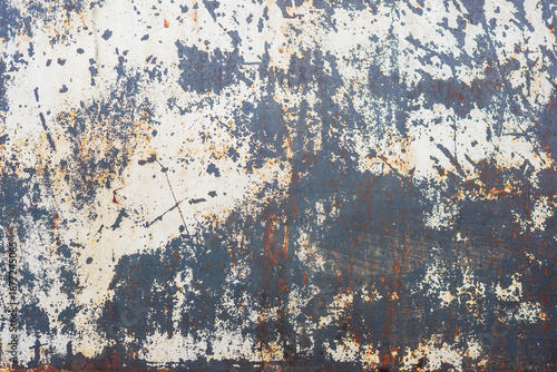 The walls are covered in peeling paint and have a rough texture. The blue color of the walls is faded and has a worn appearance. The walls have numerous cracks and holes.