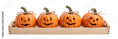 Four carved pumpkins with smiling faces arranged in wooden tray, perfect for Halloween decorations. vibrant orange color adds festive touch