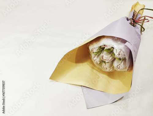 Bouquet of tulips made of marshmallow in wrapping paper on a white background.
