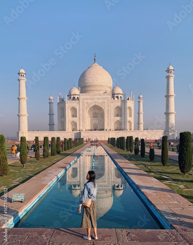 A young Asian solo traveler enjoys the view of Taj Mahal in India - Solo backpacking and budget trip in Asia 