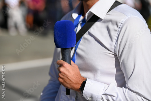 Journalist holding microphone while reporting to a live program. TV reporter. 