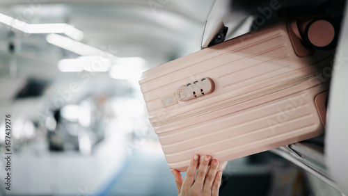 Obraz na plátně Traveler putting carry on luggage overhead bin airplane cabin flight passenger a