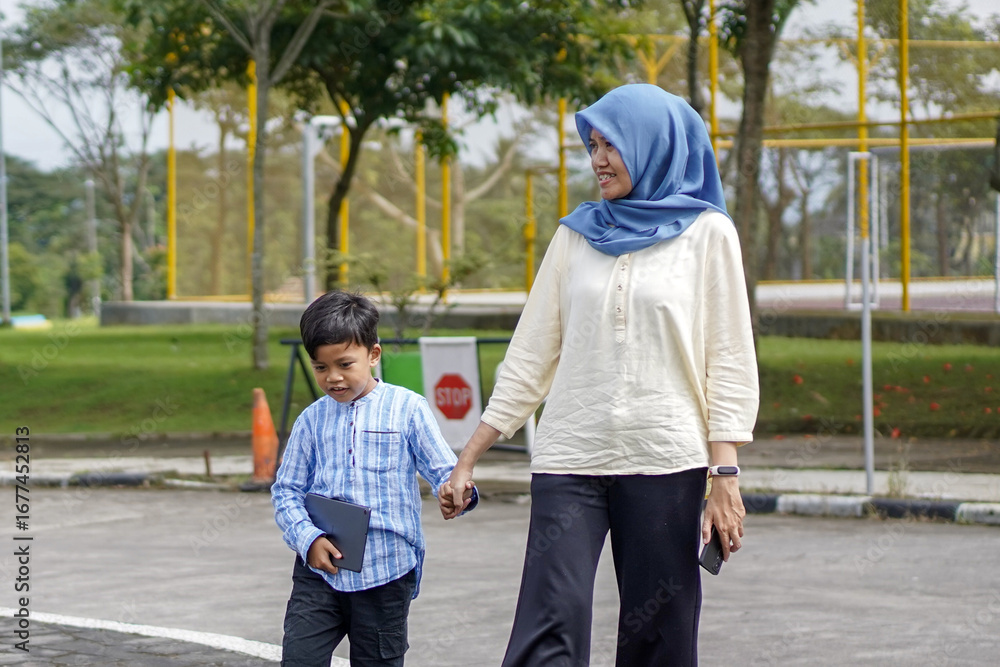 Fototapeta premium Mother and son holding hands while crossing the road, a moment of connection, walking in a safe environment, focus on family, portrait
