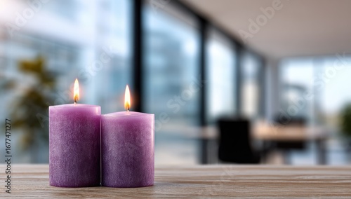 Two burning purple candles on a wooden table with a blurred modern interior background.