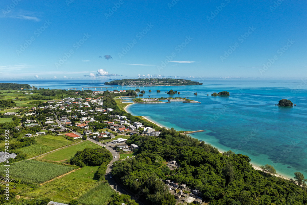 Fototapeta premium Scenic Aerial View of Yagaji Island (屋我地島) and Kouri Island (古宇利島) with Coastal Village and Beach, Okinawa, Japan