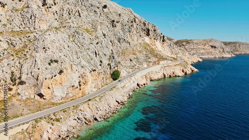 Car drive by the sea curved road near a tranquilly Aegean sea on Greek island. Aerial footage