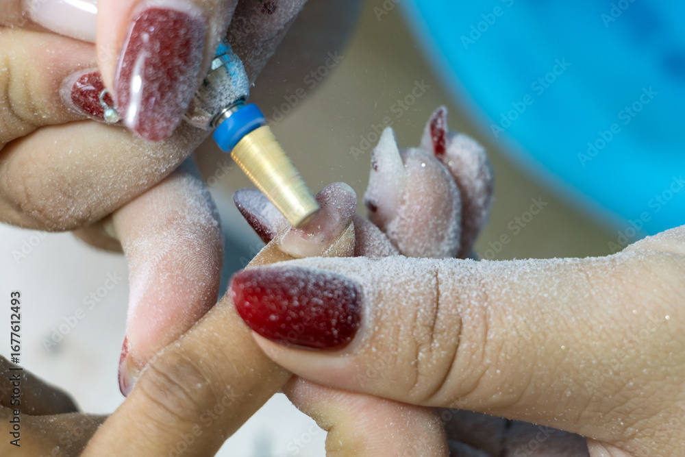 Fototapeta premium Nail treatment - gel nail removal in salon, close-up view