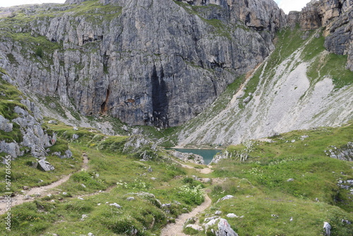 Trentino, Italy - July 29, 2025: Panoramic view of the majestic Piz Boe and the surrounding Dolomite peaks, with lush green valleys and scattered snow, under a clear blue sky. beautiful view to Lake b