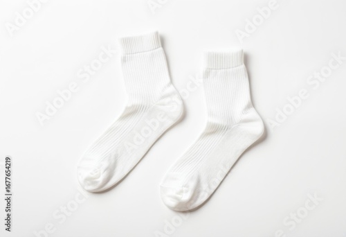 A pair of white socks on a white surface.