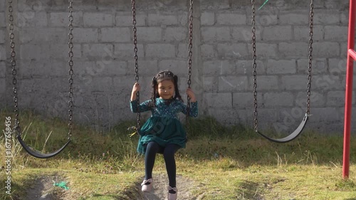 Happy child swinging on a playground swing