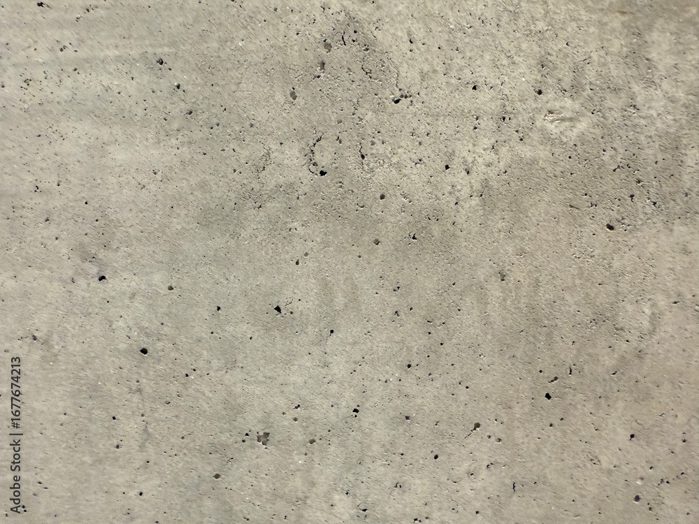 Fototapeta premium Close-up view of a concrete wall texture, showcasing its rough surface and industrial character. Ideal as a background for architecture, construction, or design projects needing a raw and urban.